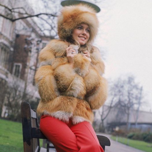 Η Olivia Newton-John φορώντας ένα βαρύ γούνινο παλτό έξω από το ξενοδοχείο Savoy στο Λονδίνο, 1... 1