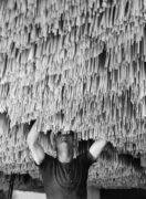 Ένας εργάτης κρεμάει ζυμαρικά για να στεγνώσει σε ένα εργοστάσιο στην Ιταλία, 1932. (Φωτογραφία Alfred Eisen...