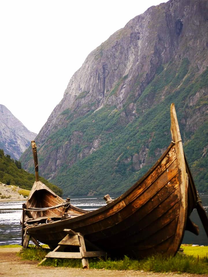 Νορβηγία. Μία παλιά ξύλινη βάρκα στο βάθος του φιόρδ ενώ ο Βίκινγκ στέκει αγέρωχ 1